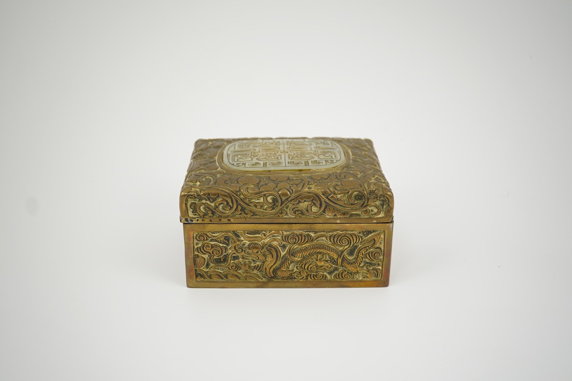 A Chinese brass 'dragon' box, inset with a 17th/18th century jade plaque